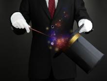 Magician performing on dark background, Africa Studio / Shutterstock.com Magician performing on dark background, Africa Studio / Shutterstock.com