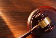 Judge's gavel on a brown table. Via: Shutterstock / sergign