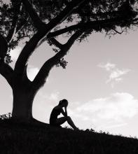A figure weeps under a tree. Image courtesy KieferPix/shutterstock.com A figure weeps under a tree. Image courtesy KieferPix/shutterstock.com