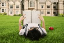 A female college student reads a book. Image courtesy Creativa/shutterstock.com