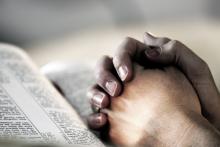 Photo: Hands clasped in prayer. Lincoln Rogers / Shutterstock.com