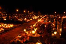 Candles illuminate a cemetery on All Saints' Day, wawritto / Shutterstock.com