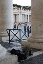 A homeless man sits close to where the showers are going to be built in St. Peter’s square. Photo via Josephine McKenna/RNS