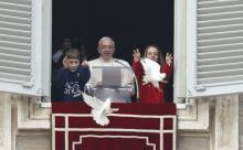 Pope Francis watches as children release doves from his window. Photo: Paul Haring, Catholic News Service/via RNS