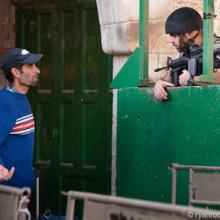 A Palestinian man is questioned at an Israeli military checkpoint in the West Bank. By Ryan Roderick Beiler http://bit.ly/sf1Pgt A Palestinian man is questioned at an Israeli military checkpoint.
