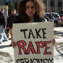 Protester holding placard, 2010. Image via Wylio. http://bit.ly/rXM1Om