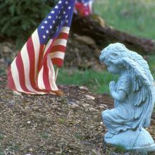 Close-up of a statue and an American flag, Purestock / Getty Images