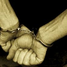 Hands in handcuffs, Digital Vision. / Getty Images