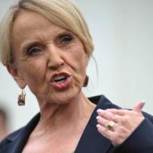 Arizona Gov. Jan Brewer speaks to reporters in 2010. Photo via Getty Images. 