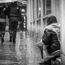 Pedestrians passing by homeless person, uros1210 / Shutterstock.com