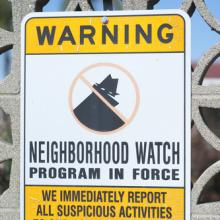 Neighborhood watch sign on a gate. Photo courtesy gabriel12/shutterstock.com