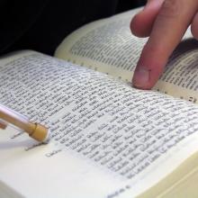 Student pointing at bible, Nir Levy/Shutterstock.com.
