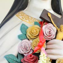 Flowers and crucifix in the hand of holy women. Image via GOLFX/shutterstock.com