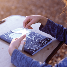 A child sits at a desk with a notebook.