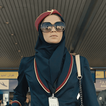 A spy dressed as a flight attendant with sunglasses exits the Tehran airport