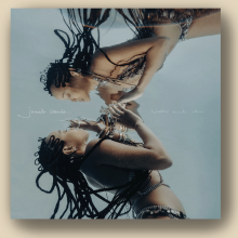 The image shows the album cover of Jamila Woods' album "Water Made Us," in which she is starring at her reflection in the water. 