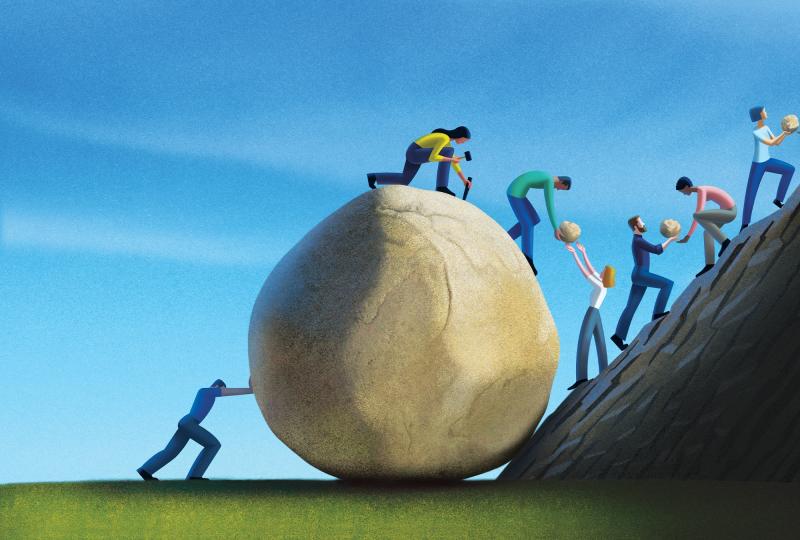 Humans working together to take apart a giant boulder into pieces to carry it up a mountain.