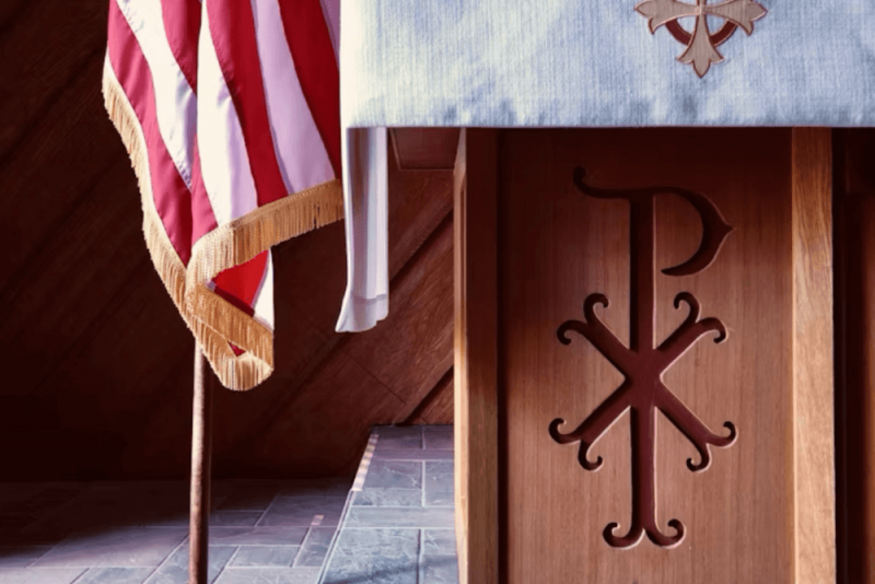 Image of a church pulpit and an american flag next to it 