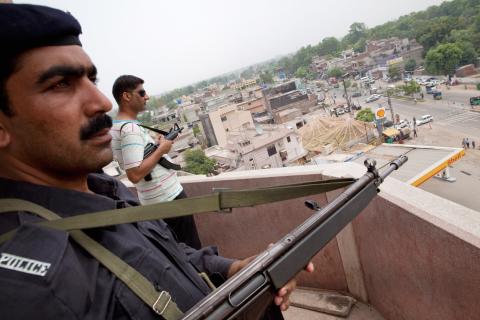 Guards keep watch atop a mosque as members of the persecuted Ahmad gather. Daniel Berehulak/Getty Images Daniel Berehulak/Getty Images