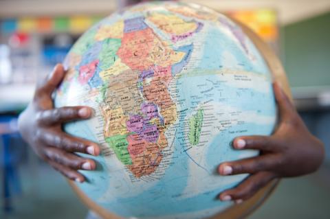 Boys hands hugging globe in classroom / Getty Images Boys hands hugging globe in classroom / Getty Images