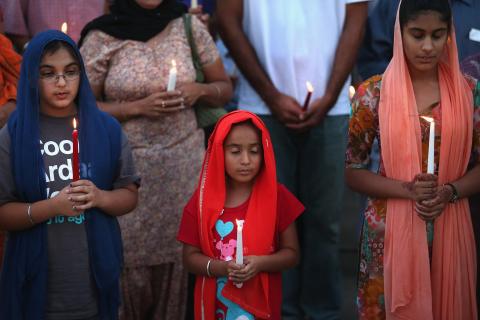 Guests attend an interdenominational candlelight vigil at the Illinois Sikh Community Center on Monday. Scott Olson/Getty Images Scott Olson/Getty Images