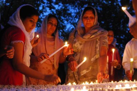 Members of Wisconsin's Sikh community hold a candle-light vigil for six people killed in an attack a day earlier.