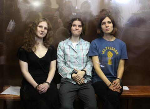 Members of the all-girl punk band sit in a glass-walled cage after being sentenced in Moscow. AFP/GettyImages AFP/GettyImages