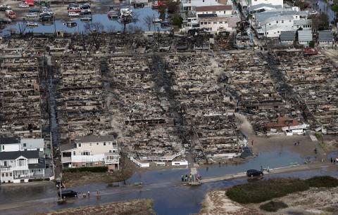People gather around the remains of burned homes after Superstorm Sandy. Mario Tama/Getty Images Mario Tama/Getty Images