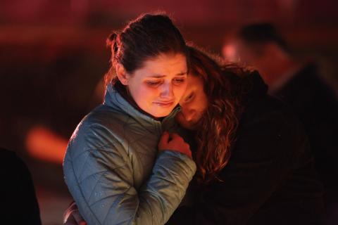 Rachel Berger (L), and Greta Waag embrace while visiting a makeshift memorial in Newtown. John Moore/Getty Images John Moore/Getty Image