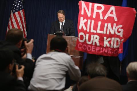 A demonstrator from CodePink holds up a banner as the NRA's Wayne LaPierre delivers remarks. Chip Somodevilla/Getty Images Chip Somodevilla/Getty Images