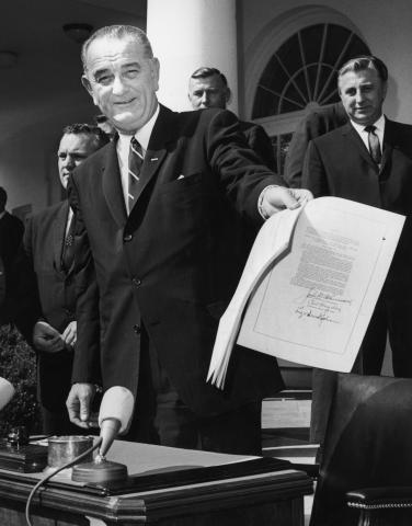 President Lyndon B Johnson smiles as he holds up the 'War on Poverty' Bill.Arnold Sachs/Consolidated News Pictures/Getty Images Arnold Sachs/Consolidated News Pictures/Getty Images