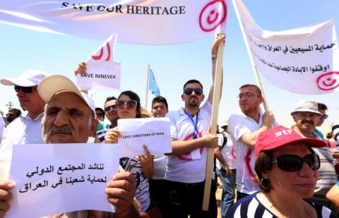 Iraqis holds up a banner with the red letter 'N' in Arabic, which stands for Christian. SAFIN HAMED/AFP/Getty Images SAFIN HAMED/AFP/Getty Images