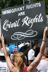 A protester holds a sign for immigration reform in Washington, DC on May 1st, 2010. Photo: Nevele Otseog/Flickr.