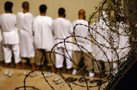Detainees stand during an early morning Islamic prayer at the prison for 'enemy combatants', in Guantanamo Bay. Getty Images. Guantamo Bay prison image by John Moore/Getty Images.