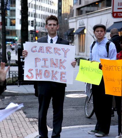 A Pink Smoke rallier holds a sign during prayers in downtown Washington, DC. Photo courtesy Ted Majdosz.