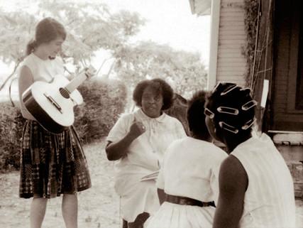 Heather Booth plays guitar for Fannie Lou Hamer during the Freedom Summer, Mississippi, 1964. Creative Commons:Wallace Roberts.