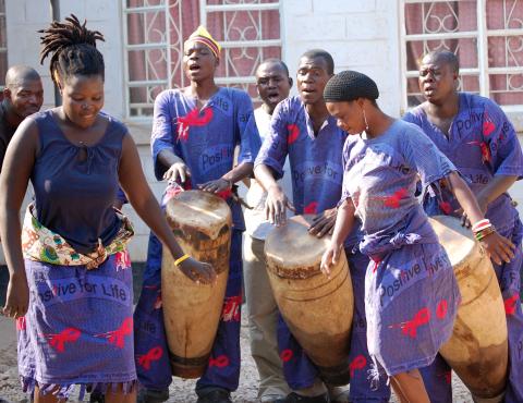 Drummers and dancers perform songs to educate a community about HIV and AIDS in Zambia.