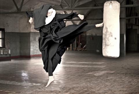Nun kicks a heavy bag in a gym. Photo by Martin San/Getty Images. Nun kicks a heavy bag in a gym. Photo by Martin San/Getty Images.