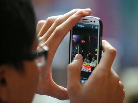 Man using Instagram to share photo, 1000 Words / Shutterstock.com Man using Instagram to share photo, 1000 Words / Shutterstock.com