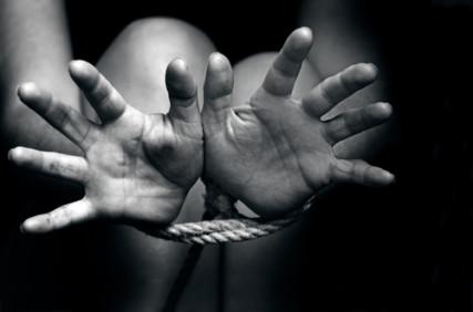 Hands tied with rope. Photo courtesy of ChameleonsEye via Shutterstock