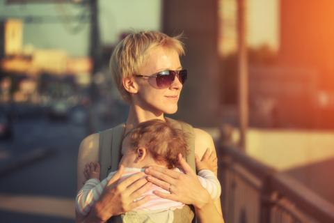 A mother carries her child through a city. Image via Konstantin Sutyagin/shutterstock.com A mother carries her child through a city. Image via Konstantin Sutyagin/shutter