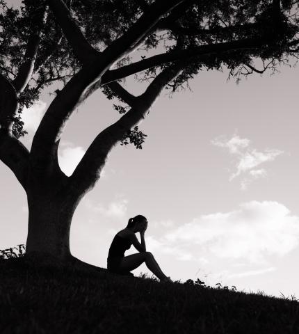 A figure weeps under a tree. Image courtesy KieferPix/shutterstock.com A figure weeps under a tree. Image courtesy KieferPix/shutterstock.com