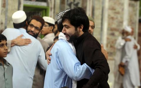 Muslims hug with each other after Eid-ul-Fitar prayer in Peshawar, Pakistan. Photo via Asianet-Pakistan / Shutterstock.com Photo via Asianet-Pakistan / Shutterstock.com