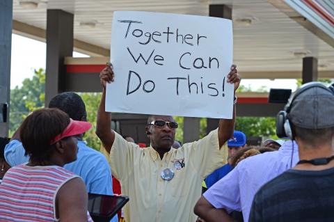 Man holds sign at QuickTrip in Ferguson, Mo., on Aug. 15. R. Gino Santa Maria / Shutterstock.com R. Gino Santa Maria / Shutterstock.com