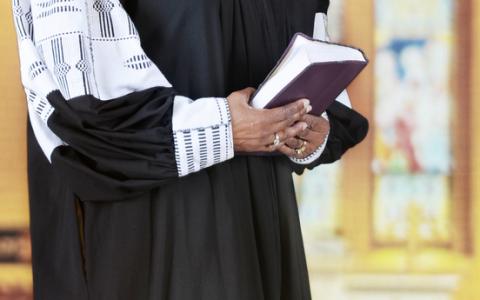 Female clergy holding a Bible, glenda / Shutterstock.com Female clergy holding a Bible, glenda / Shutterstock.com