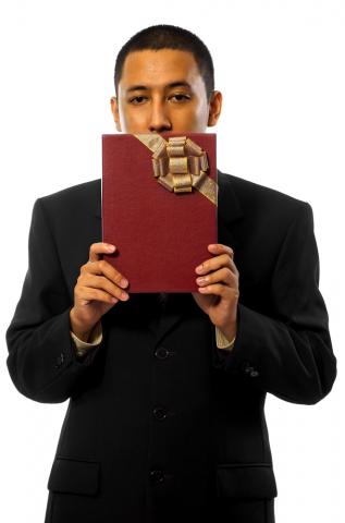 Man wearing black holds a gift. Image courtesy Man wearing black holds a gift. Image courtesy leolintang/shutterstock.com. Man wearing black holds a gift. Image courtesy Man wearing black holds a gift. I