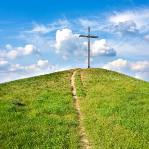 A cross stands in a meadow. Photo courtesy Pavelk/shutterstock.com