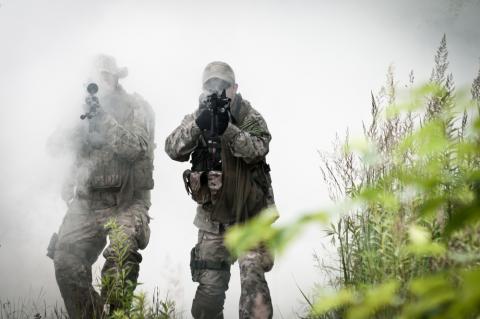 Special forces troops patrol in the smoke. Photo by Przemek Tokar/Shutterstock.com. Photo by Przemek Tokar/Shutterstock.com.