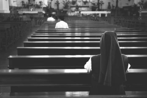 A back view of praying sister inside church. Tito Wong / Shutterstock Tito Wong / Shutterstock