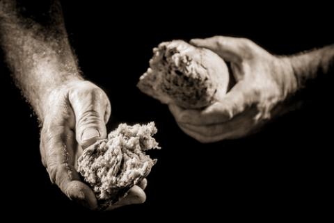 Hands breaking bread. Photo courtesy Shaiith/shutterstock.com